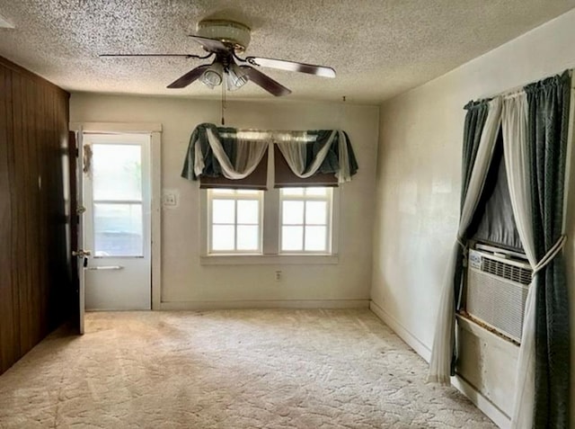 spare room with ceiling fan, light colored carpet, and a textured ceiling