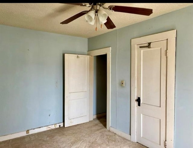 unfurnished bedroom with ceiling fan, light colored carpet, and a textured ceiling