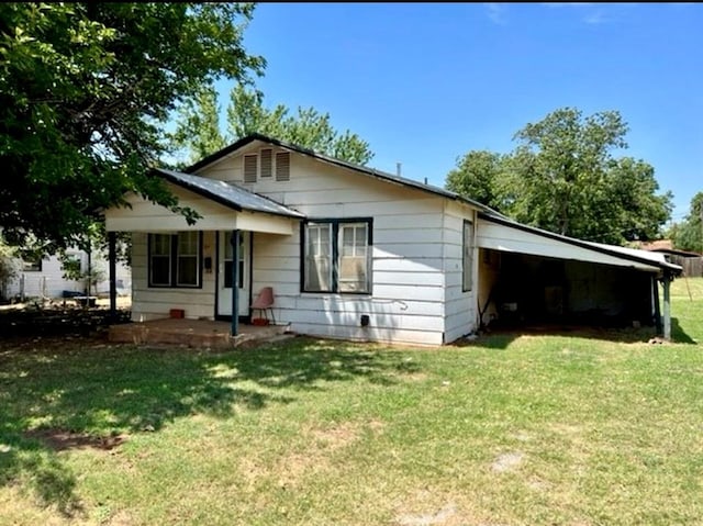 view of front of house featuring a front lawn and a carport