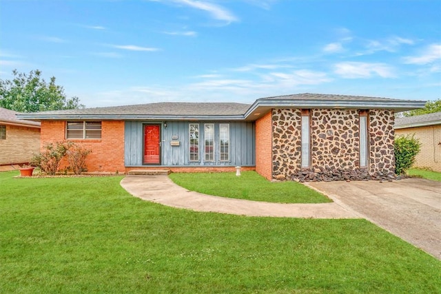 ranch-style house with board and batten siding and a front lawn