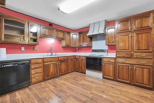 kitchen featuring a sink, light wood-style floors, wall chimney range hood, dishwasher, and white range with electric cooktop