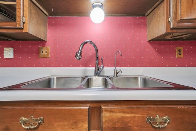 kitchen featuring brown cabinetry and a sink