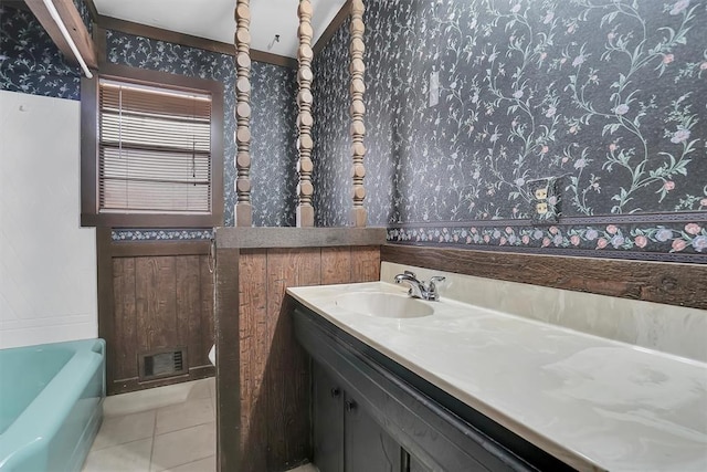 bathroom with visible vents, vanity, a bathing tub, and tile patterned floors