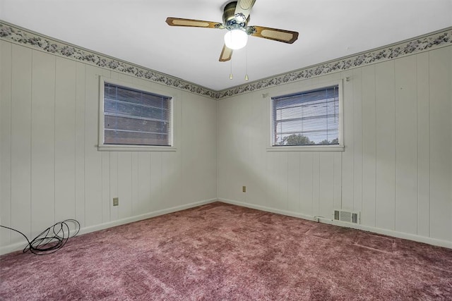 spare room with carpet floors, ceiling fan, visible vents, and baseboards