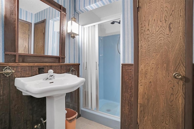 full bathroom with a stall shower and wallpapered walls