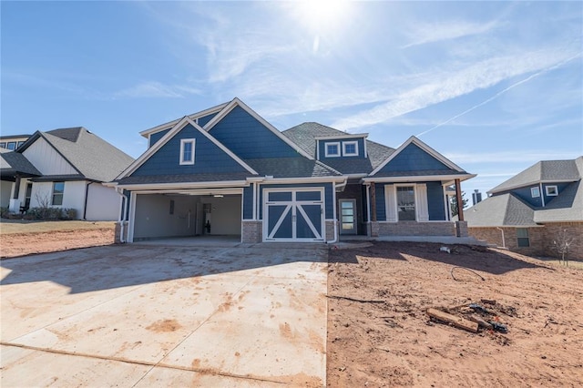 view of front of home with roof with shingles, concrete driveway, and brick siding