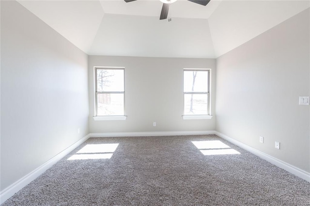 carpeted spare room with a ceiling fan, vaulted ceiling, and baseboards