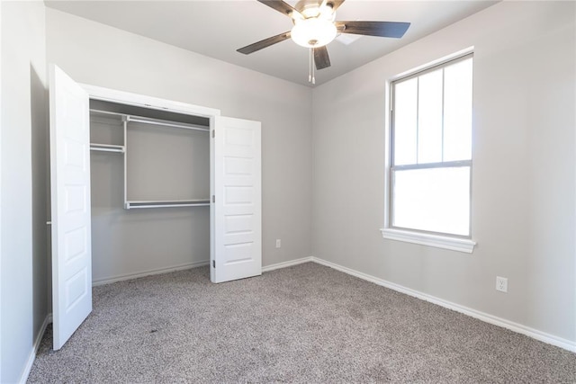 unfurnished bedroom featuring ceiling fan, carpet floors, a closet, and baseboards