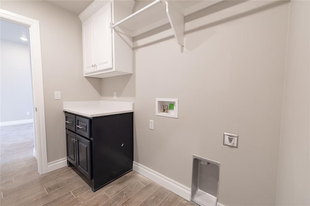 washroom featuring light wood-type flooring, washer hookup, cabinet space, and baseboards