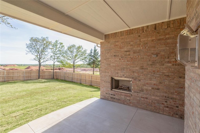 view of yard with a fenced backyard, an outdoor brick fireplace, and a patio