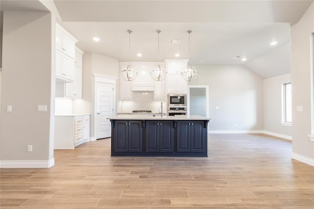 kitchen with light wood-type flooring, baseboards, white cabinetry, light countertops, and appliances with stainless steel finishes