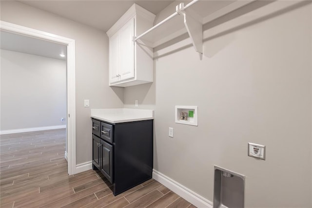 laundry room with cabinet space, washer hookup, baseboards, and light wood-style flooring