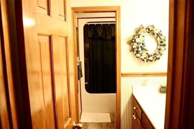 bathroom featuring shower / bathtub combination with curtain, vanity, and hardwood / wood-style flooring