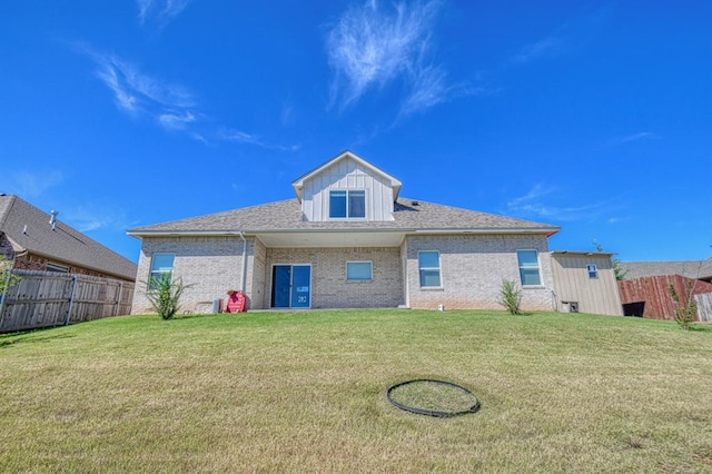 rear view of house featuring a yard