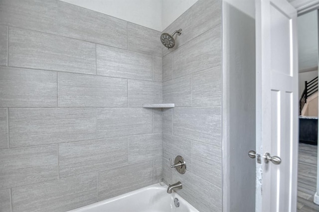 bathroom with hardwood / wood-style floors and tiled shower / bath combo