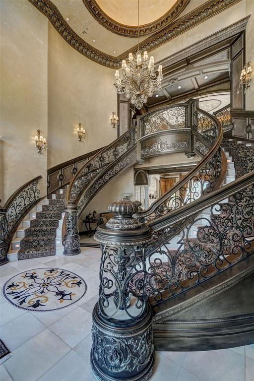 stairs with tile patterned floors, a towering ceiling, and ornamental molding