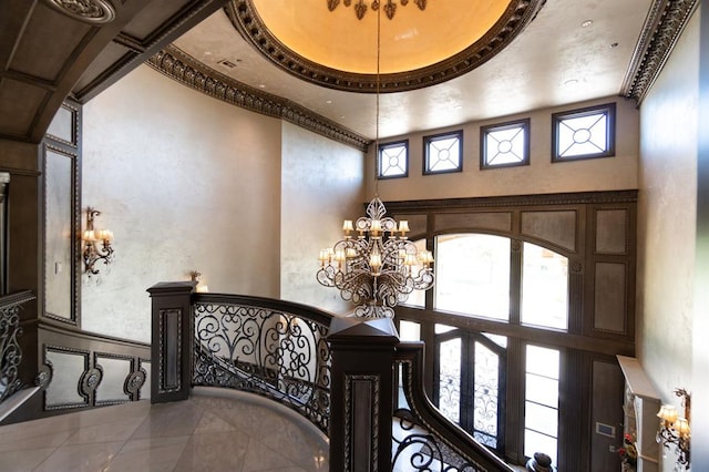 corridor with a chandelier, french doors, a healthy amount of sunlight, and a high ceiling