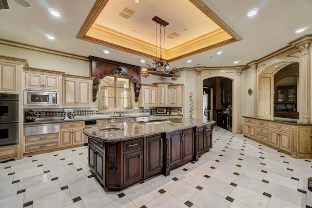 kitchen with a center island with sink, decorative light fixtures, decorative backsplash, and appliances with stainless steel finishes