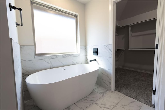 bathroom with a bathing tub and tile walls