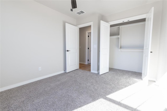 unfurnished bedroom featuring ceiling fan, a closet, and carpet