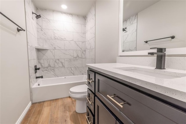 full bathroom with vanity, wood-type flooring, tiled shower / bath combo, and toilet