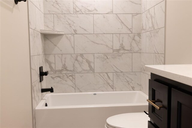 bathroom with tiled shower / bath combo and toilet