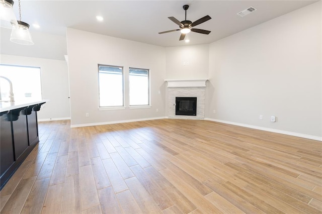 unfurnished living room with light hardwood / wood-style floors and ceiling fan