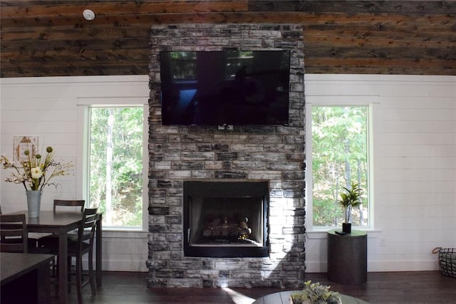 living room with a fireplace, wooden walls, and dark hardwood / wood-style flooring