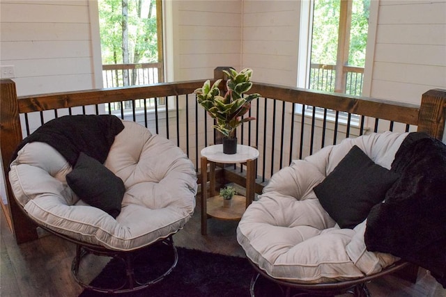 living room with wood walls, a healthy amount of sunlight, and hardwood / wood-style flooring