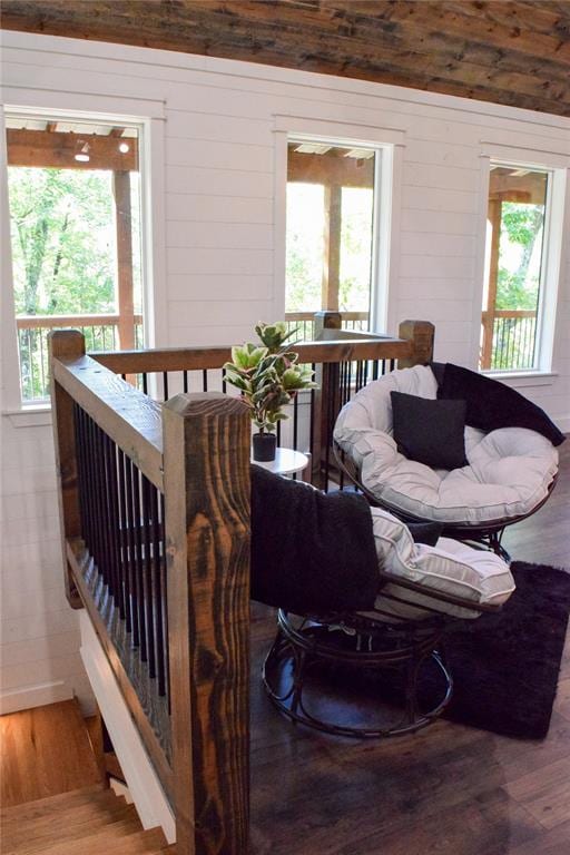 living room featuring wooden walls, hardwood / wood-style flooring, and a healthy amount of sunlight