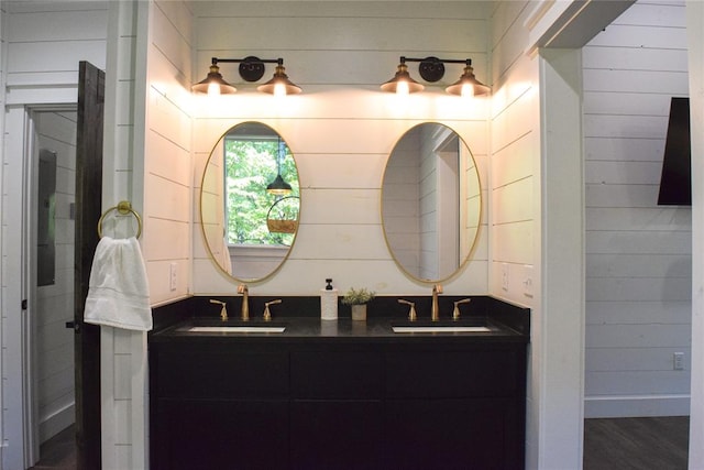 bathroom featuring hardwood / wood-style flooring, vanity, and wood walls