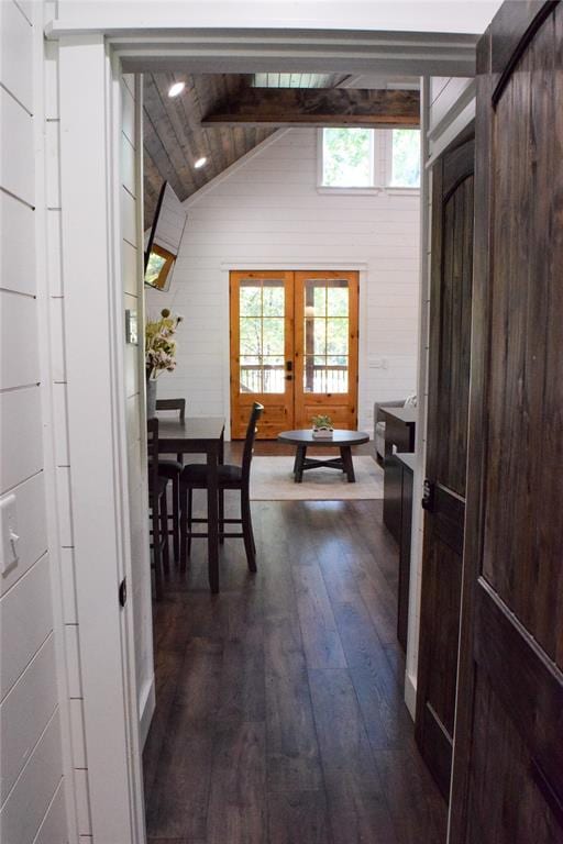 hall featuring vaulted ceiling with beams, wood walls, dark hardwood / wood-style flooring, and french doors