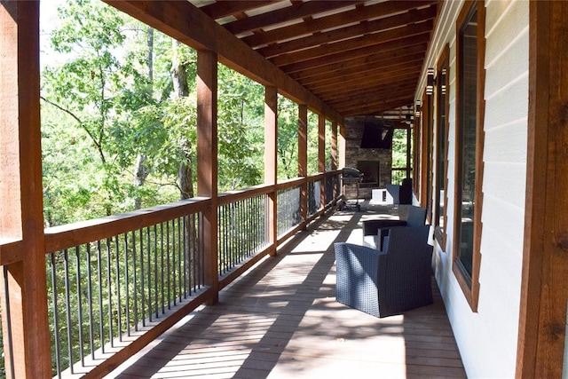 wooden terrace with an outdoor stone fireplace