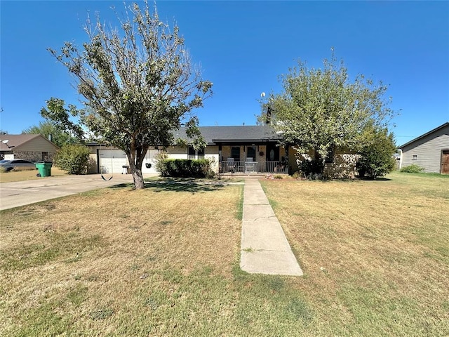 view of front of property with a porch, a garage, and a front lawn