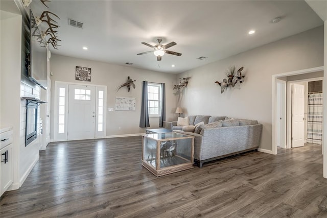 living room featuring ceiling fan and dark hardwood / wood-style floors