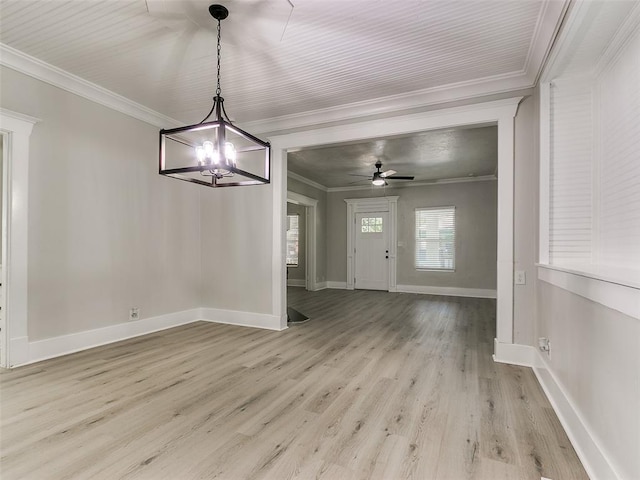 unfurnished dining area featuring ceiling fan with notable chandelier, light hardwood / wood-style floors, and crown molding