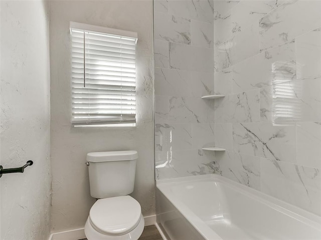 bathroom with toilet and tiled shower / bath