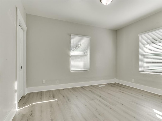 spare room featuring a healthy amount of sunlight and light hardwood / wood-style floors