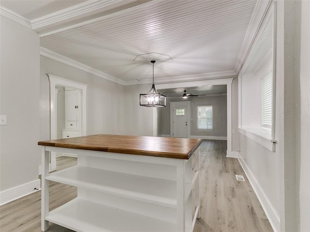 kitchen with butcher block counters, pendant lighting, light wood-type flooring, and ornamental molding