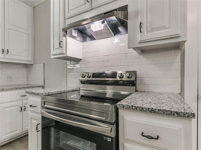 kitchen featuring decorative backsplash, light stone countertops, white cabinets, stainless steel electric range oven, and range hood