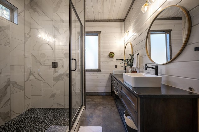 bathroom featuring wood walls, vanity, concrete flooring, and walk in shower