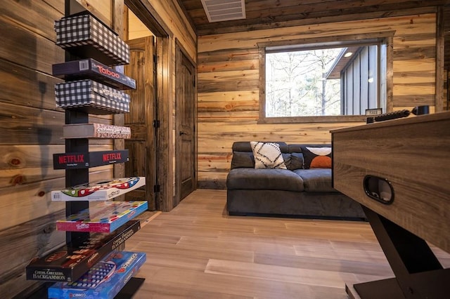 living area featuring wood walls and light hardwood / wood-style flooring