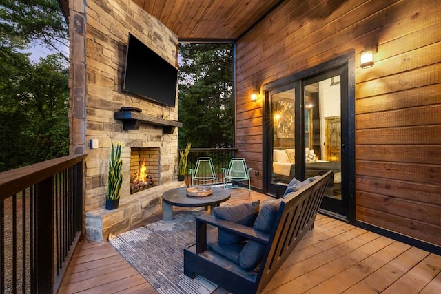 wooden deck featuring an outdoor stone fireplace