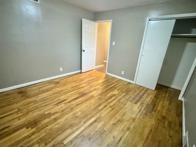 unfurnished bedroom featuring light hardwood / wood-style floors and a closet