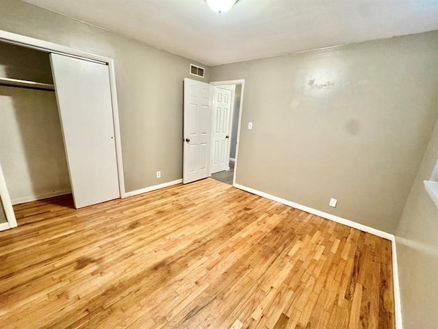 unfurnished bedroom featuring a closet and light hardwood / wood-style flooring