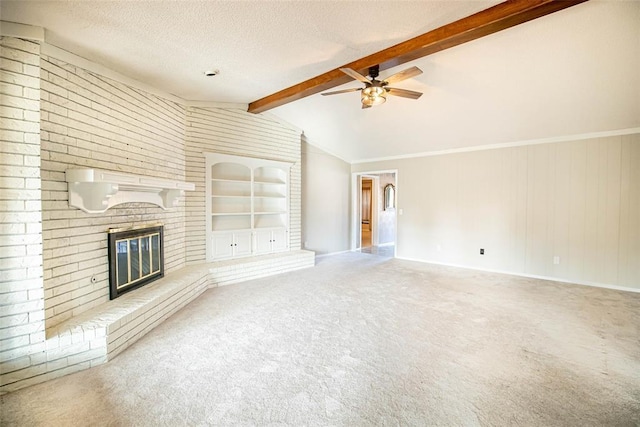 unfurnished living room featuring carpet flooring, ceiling fan, a brick fireplace, vaulted ceiling with beams, and ornamental molding