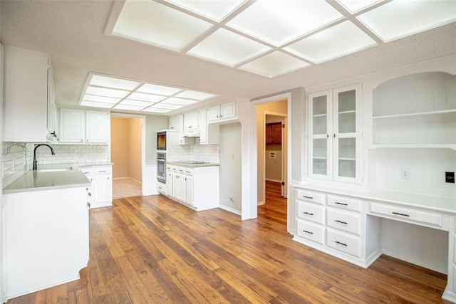 kitchen featuring white cabinets, tasteful backsplash, sink, and dark wood-type flooring