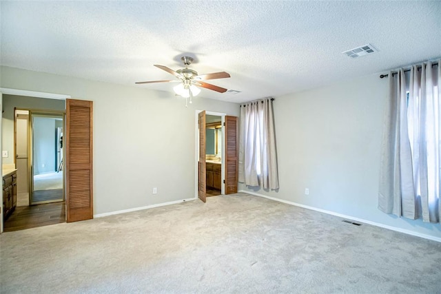 unfurnished bedroom with ensuite bath, ceiling fan, and light colored carpet