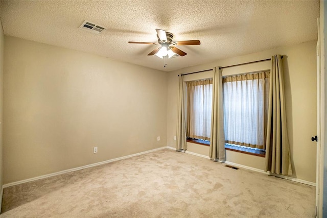 unfurnished room with light carpet, ceiling fan, and a textured ceiling