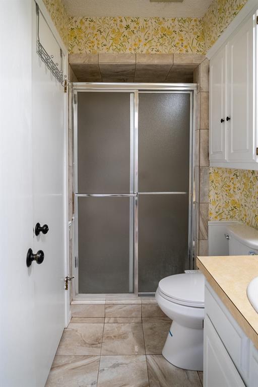 bathroom with vanity, toilet, and a shower with shower door